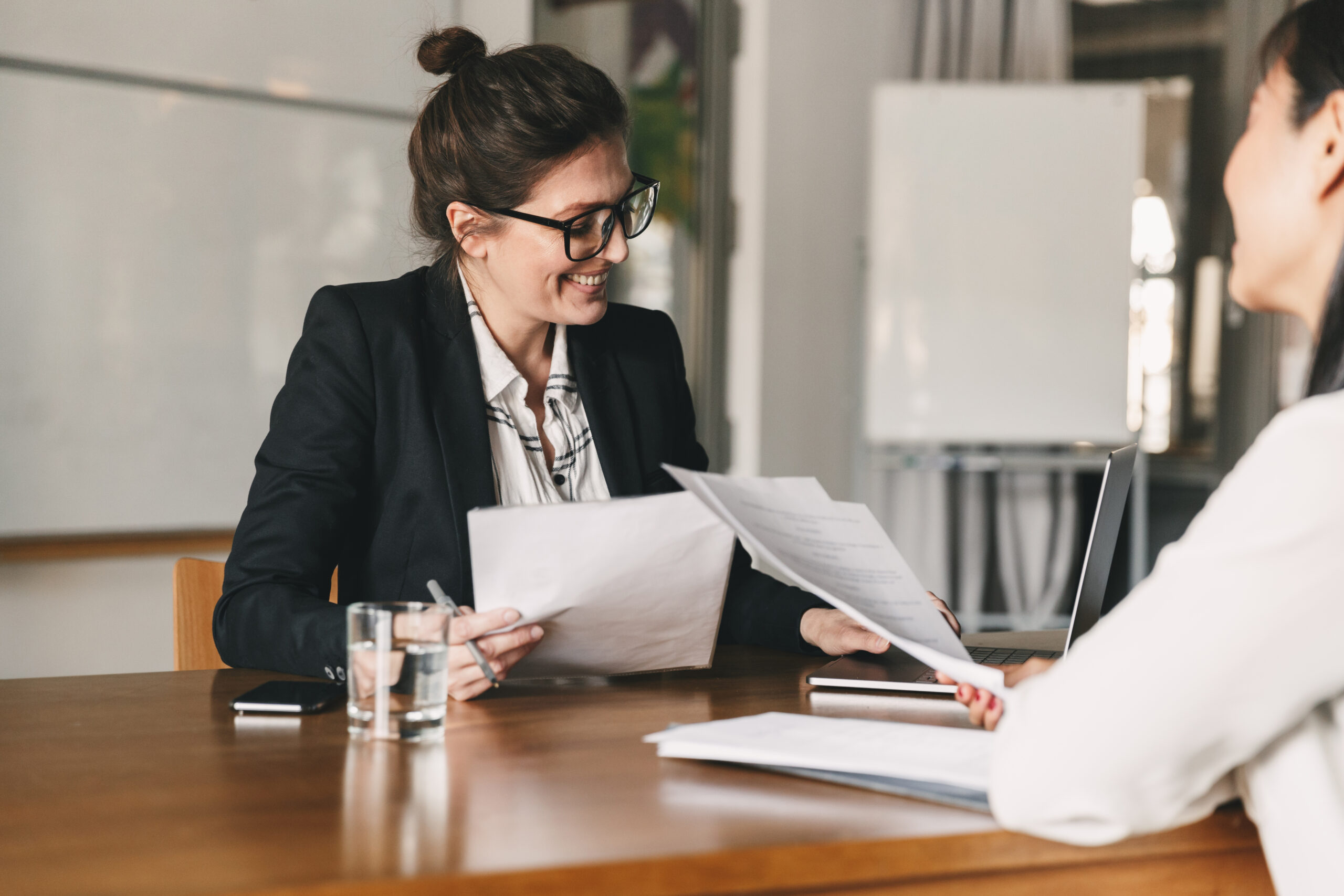 Job Interview Photo of woman holding resume and negotiating with female candidate.