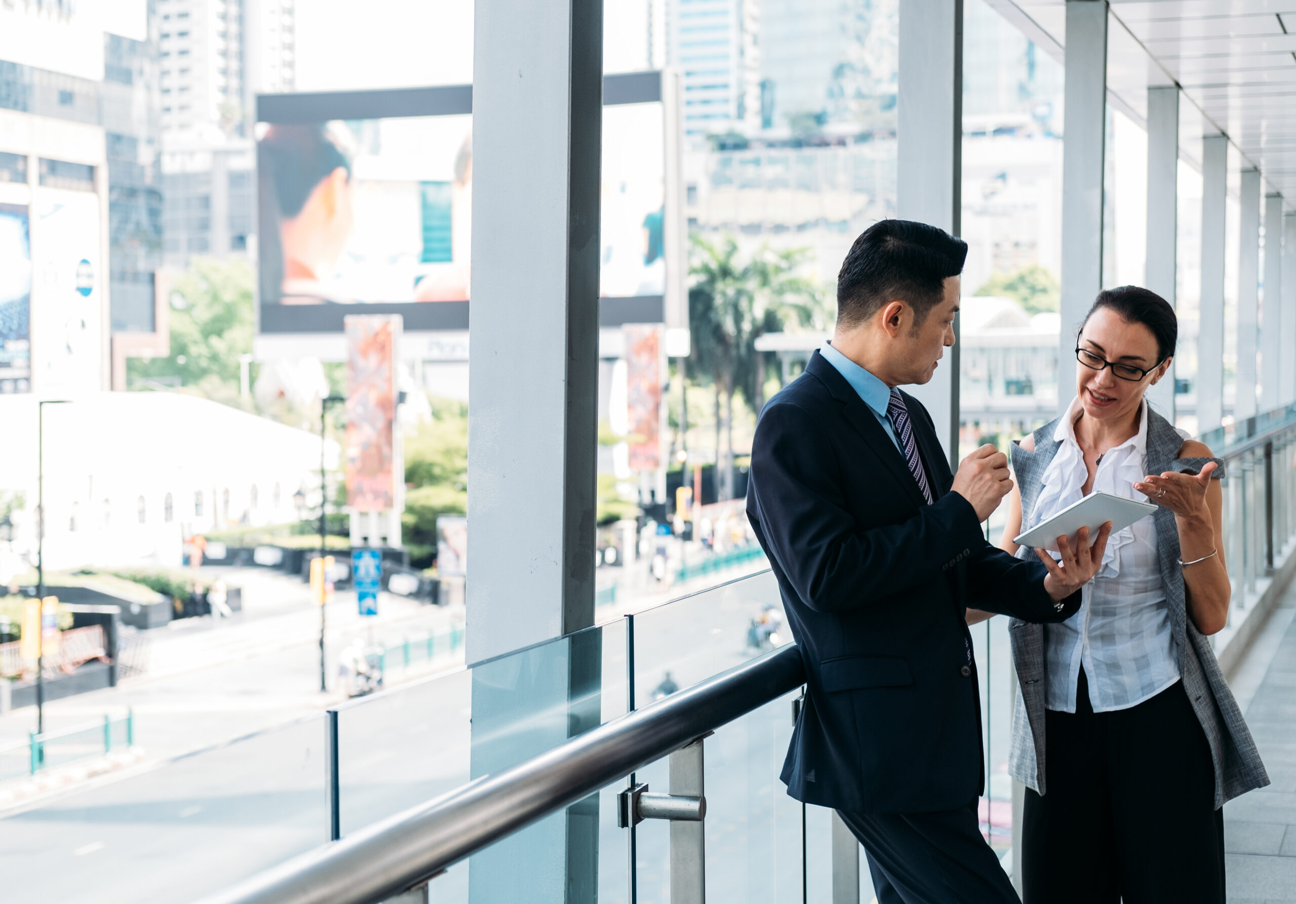Two people in an office building using a digital tablet.